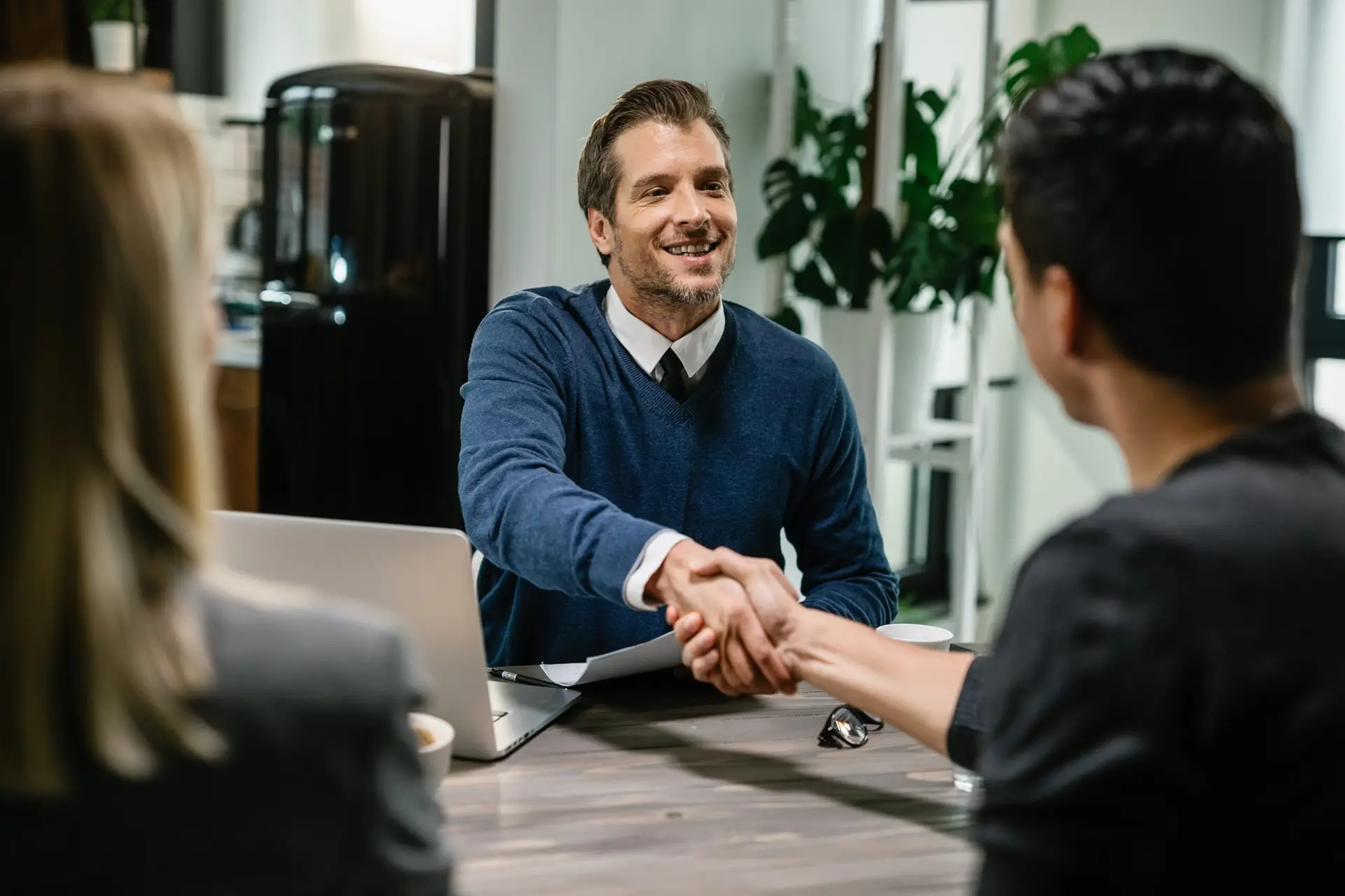 Happy consultant greeting his clients while meeting them.